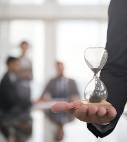 Businessman holding an hour glass, signifies the importance of being on time